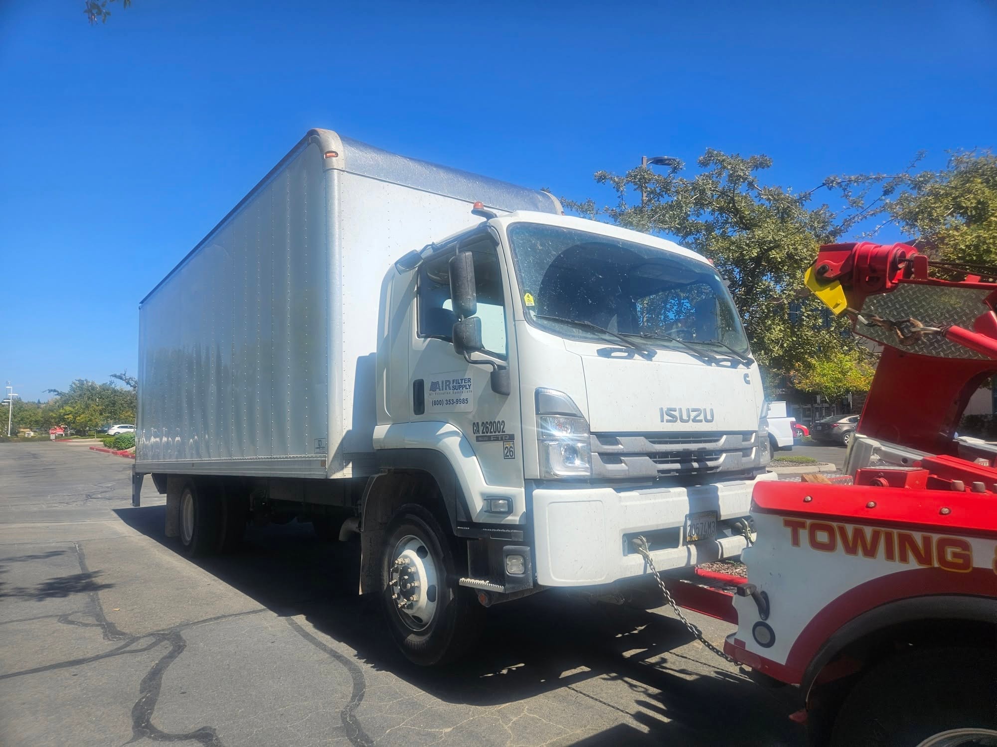 Chima's tow truck recovering a large Isuzu box truck